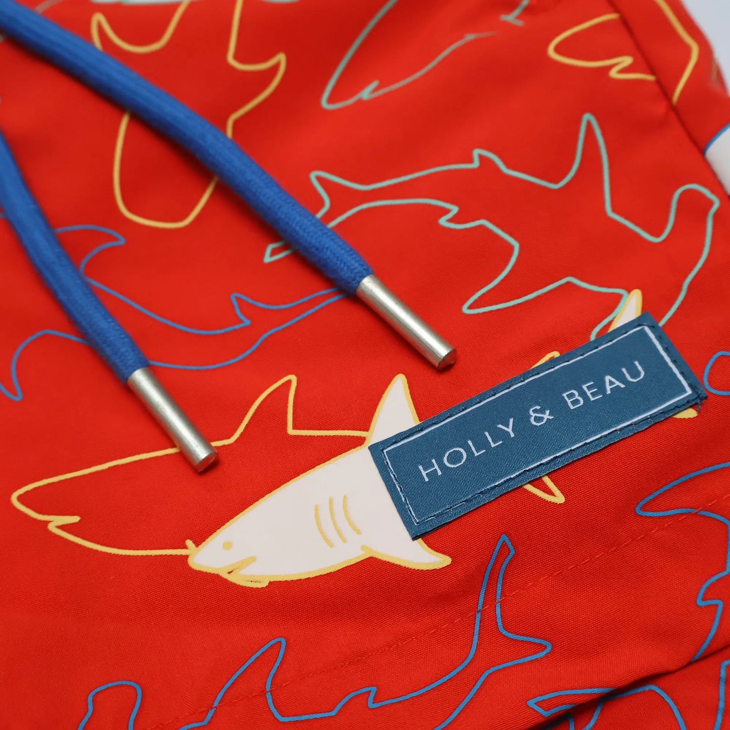 Holly and Beau Red sharks boys color changing swim trunks. Front detailed view of drawstring and logo