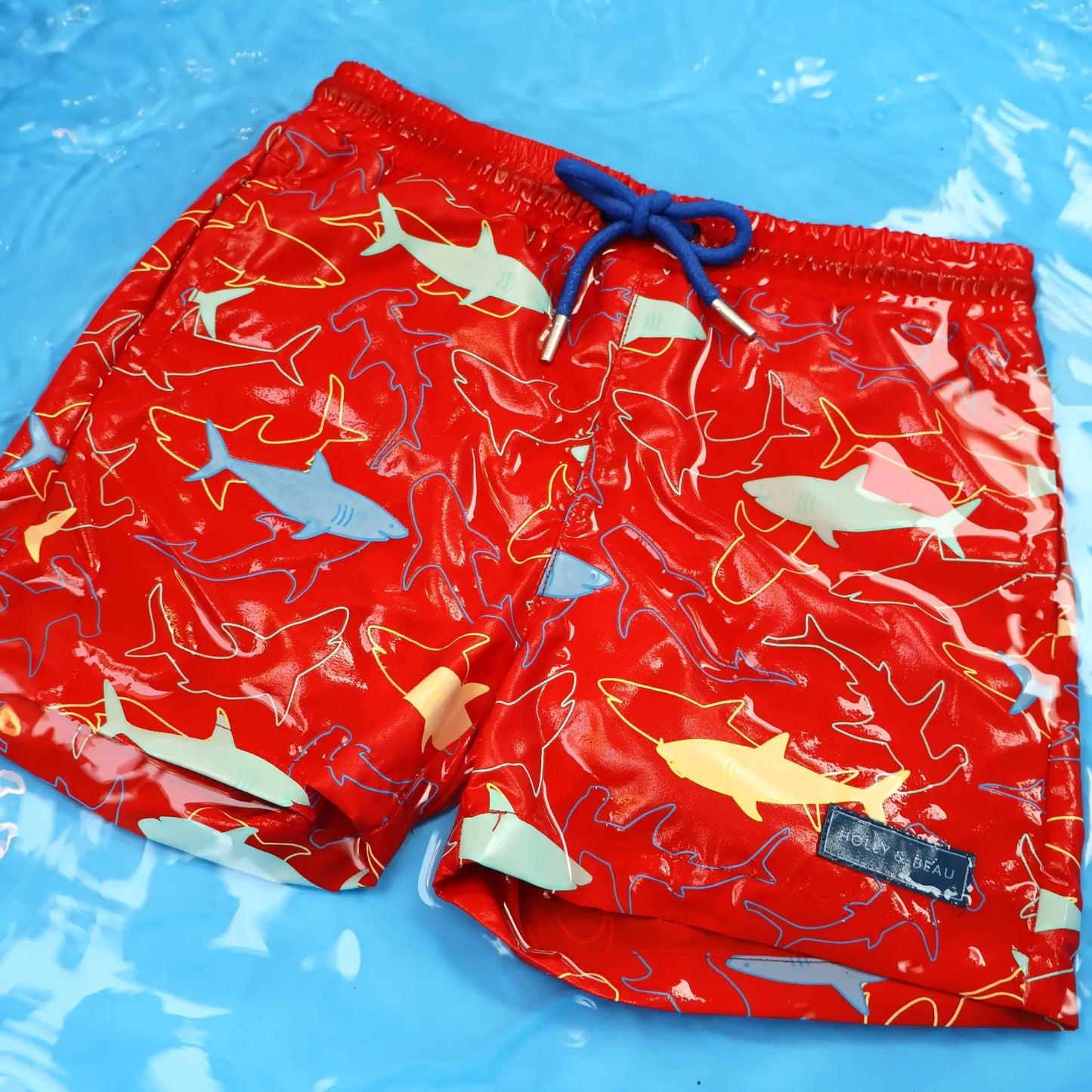Holly and Beau Red sharks boys color changing swim trunks in water after color change