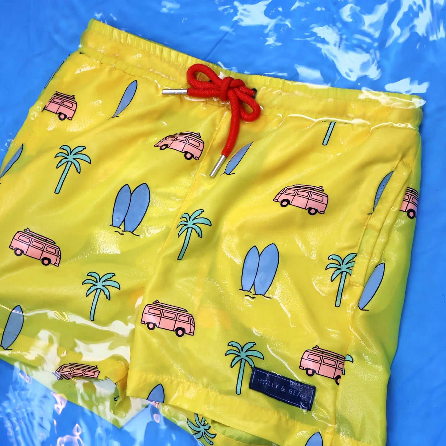 Holly and Beau Yellow surfboards boys color changing swim trunks in the water after color change