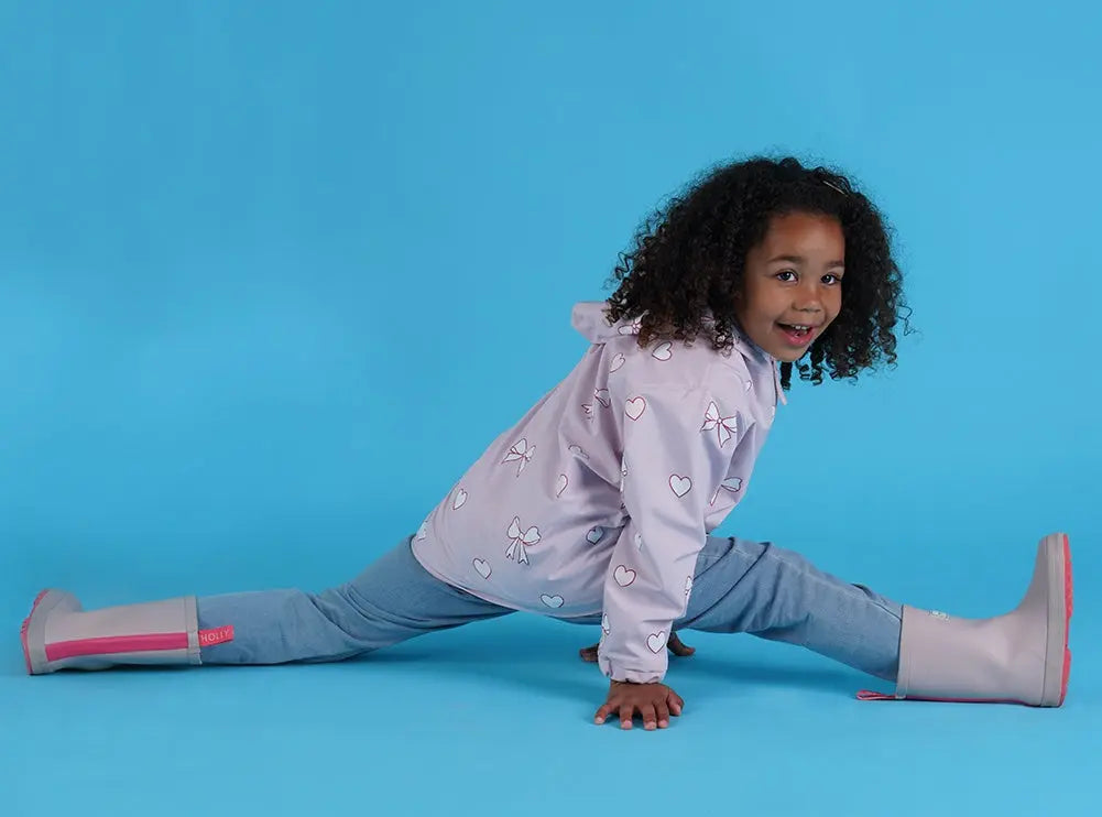 Holly and Beau Lifestyle girl dancing wearing the pink bows and hearts color changing raincoat